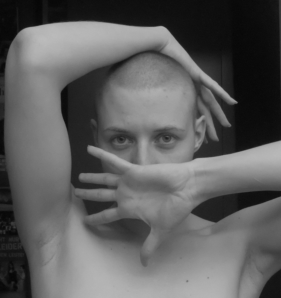 frau mit glatze hand vor dem mund blick in kamera