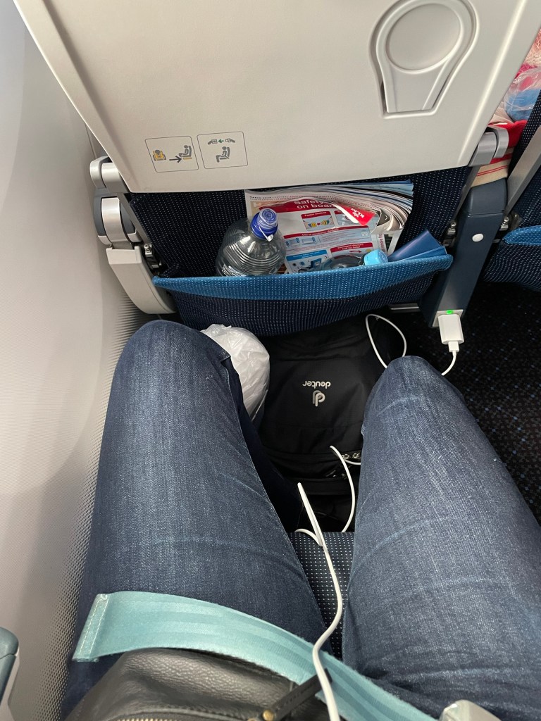 Bild meiner Beine in Jeans im Flugzeug. Meine Knie stoßen in der gegen Aufpreis buchbaren Economy Comfort nicht an den Vordersitz an. 