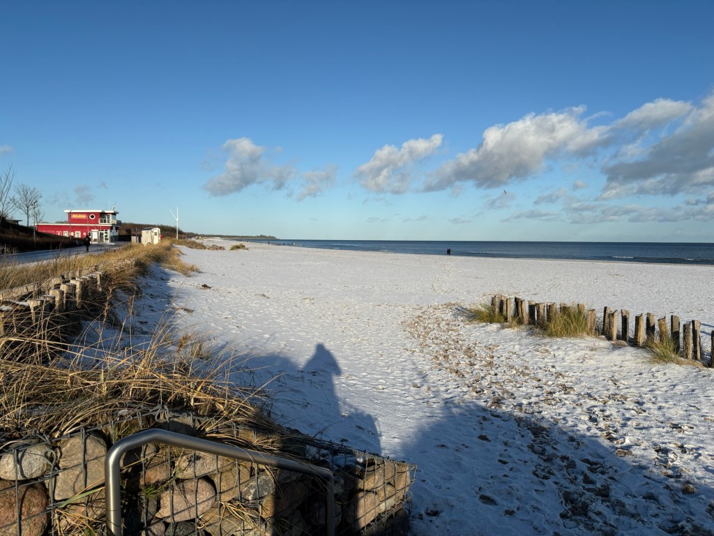 weiß verschneiter Ostseestrand bei Sonnenschein