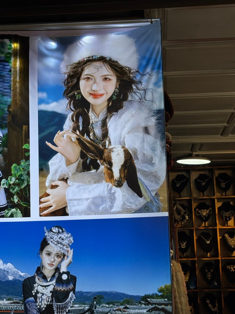 Ein stark bearbeitetes Bild einer jungen asiatischen Frau mit sehr weißem Gesicht, leicht geröteten Augen und hellbraunen Kontaktlinsen. Ihre Haare werden vom Wind leicht verweht. Sie trägt ein weißes Kostüm mit weißer Pelzmütze. Auf dem Schoß hat sie ein Zicklein und zieht dessen rechtes Schlappohr mit spitzen Fingern schräg nach oben.
Darunter ist ein weiteres Bild einer sehr blassen Asiatin zu sehen, die ein traditionelles Kostüm trägt, hinter ihr Berge.